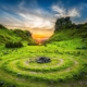 Grüne Hügellandschaft mit kreisförmigem Steinmuster im Abendlicht